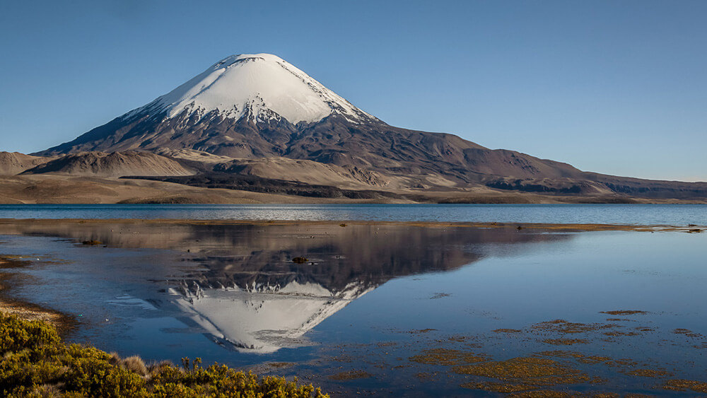 Una de las más tradicionales postales de la región, Volcán Parinacota reflejado en el Lago Chungará ©Andrés Puigross