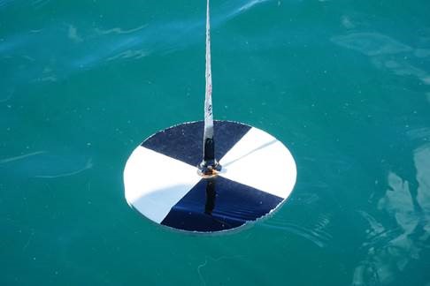 Un Disco Secchi, usado para sumergirlo y calcular la penetración de la luz a distintas profundidades y la turbiedad del agua. Crédito: CIEP.