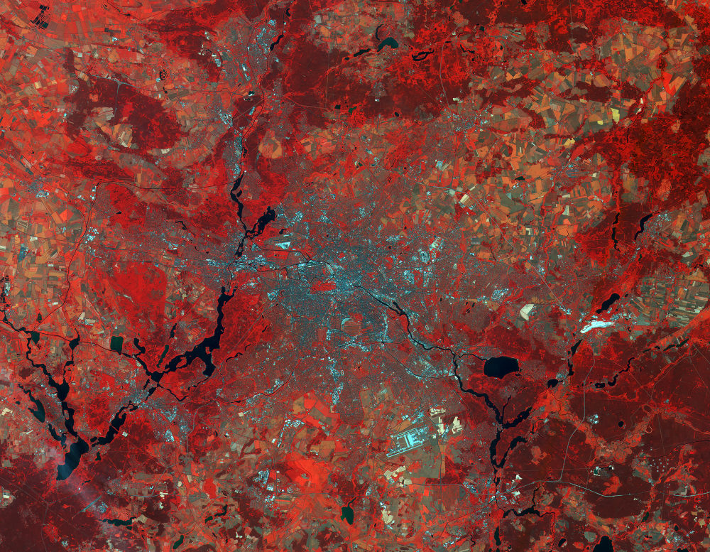 Berlin y alrededores en imagen hiperespectral de color falso para distinguir infraestructura (celeste) de vegetación (rojo), pudiendo inferir superficie forestada. (ESA/Sentinel-2). Crédito: Odd Industries.