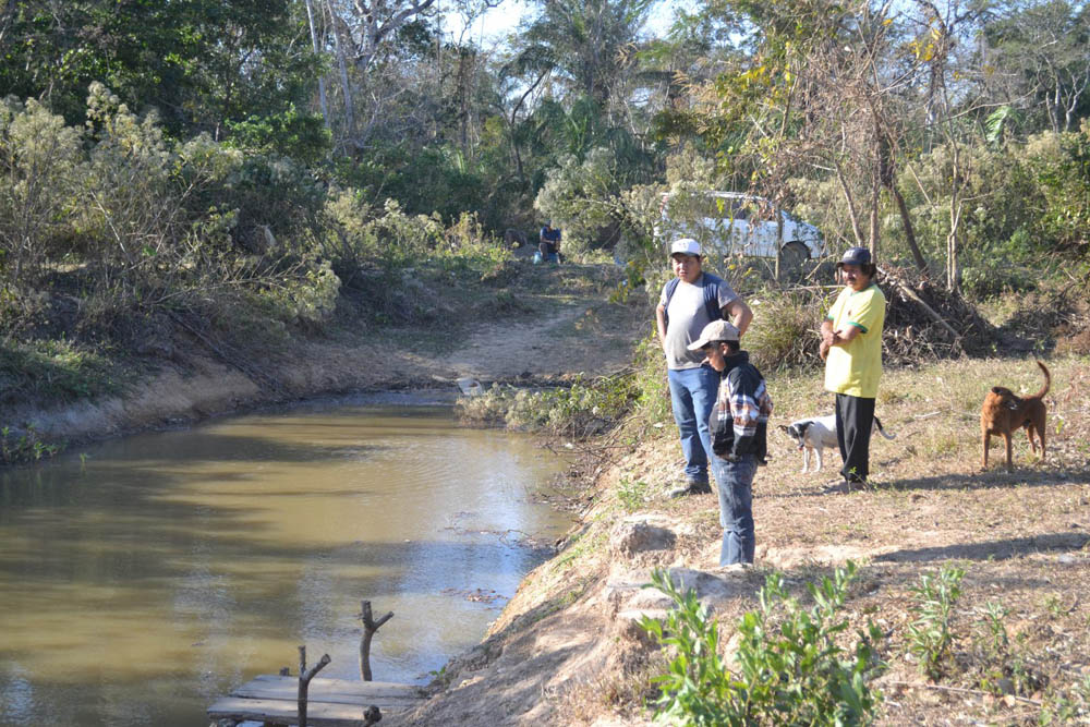 8Gilberto con su hijo y un comunario al borde del arroyo de su comunidad.