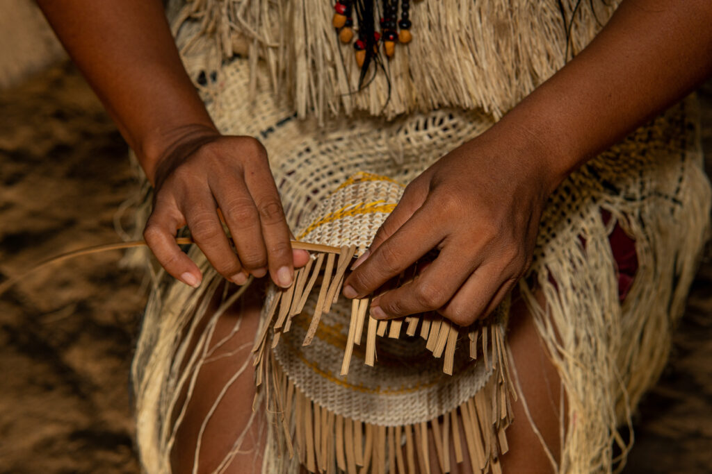 Mujer del pueblo indígena Huitoto, de la Amazonía colombiana, tejiendo una canasta tradicional. Foto: PINZONOOB / Shutterstock.com.