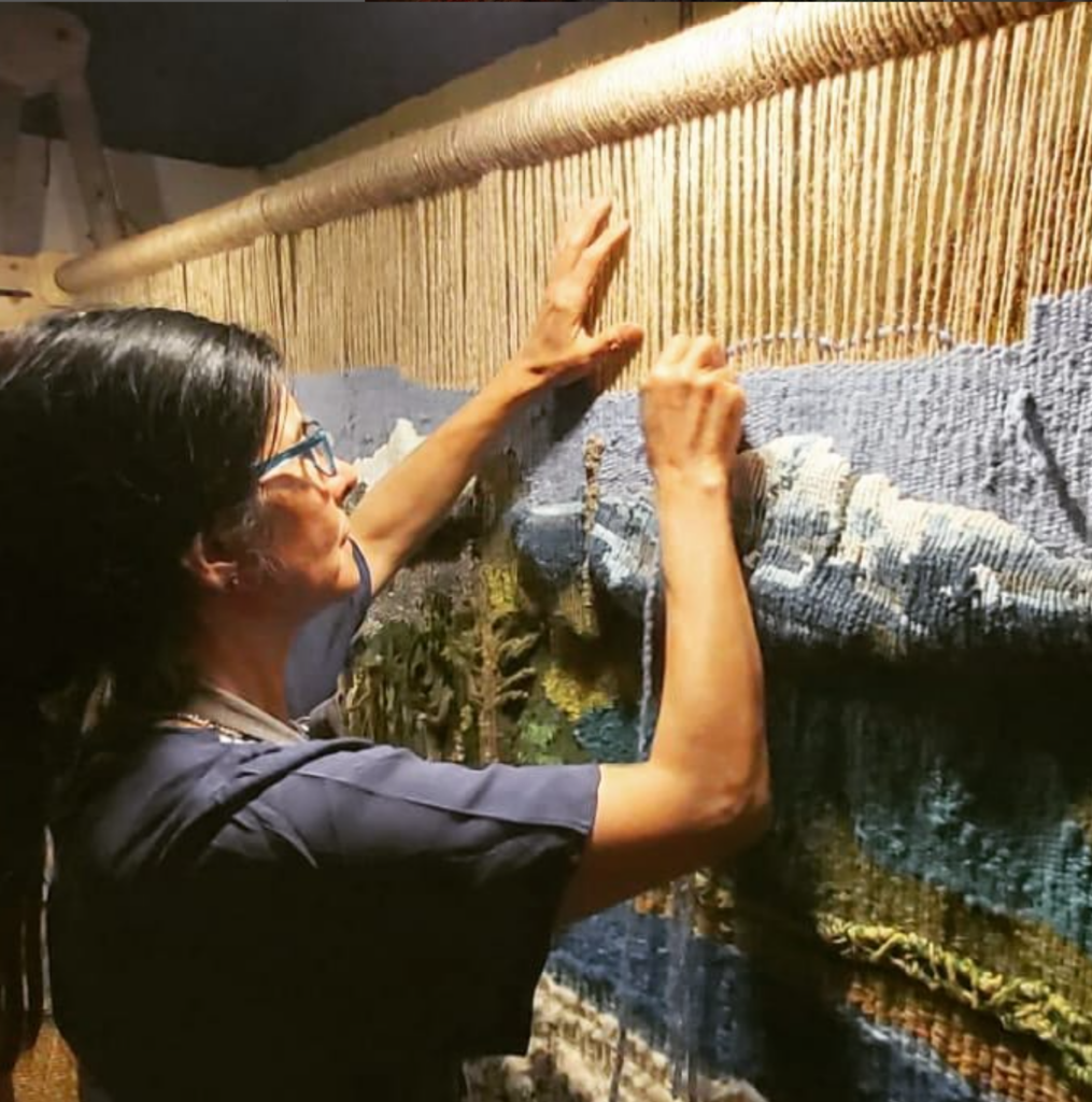 Elisa Muñoz Méndez, en su taller, con un tapiz creado por ella.