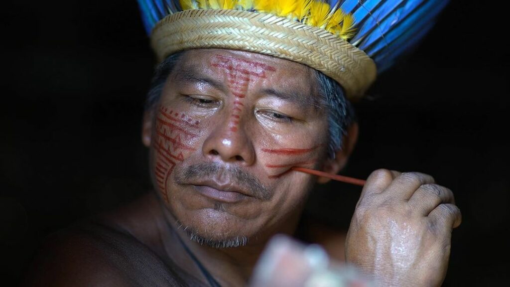 Hombre perteneciente a la comunidad indígena realizándose un maquillaje típico de su cultura. Créditos: We are Guardians.