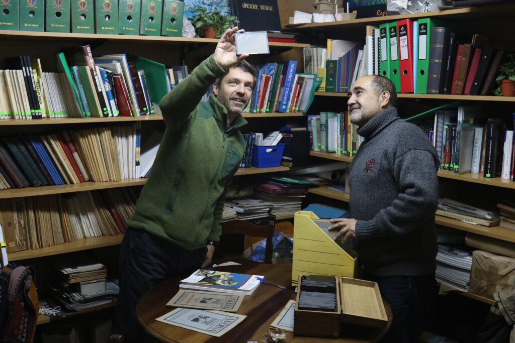 Alvaro Vivanco y Eduardo Quezada revisan las placas de vidrio en la Biblioteca del Club Alemán Andino. © Paula López Wood 