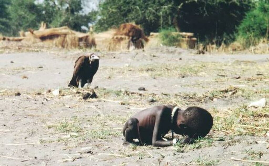 Fotografía ganadora de Pulitzer, tomada por Kevin Carter. El niño, Kong Nyong, siendo asediado por un buitre.