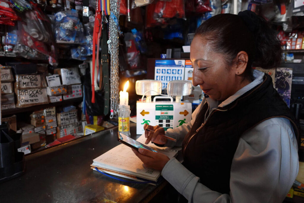 Una vendedora trabaja a la luz de las velas en Cuenca, en el sur de Ecuador. Imagen: Boris Romoleroux / Imago / Alamy