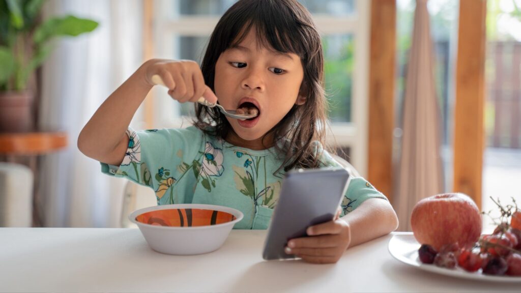 Niña jugando con un celular inteligente. Créditos: Odua Images.