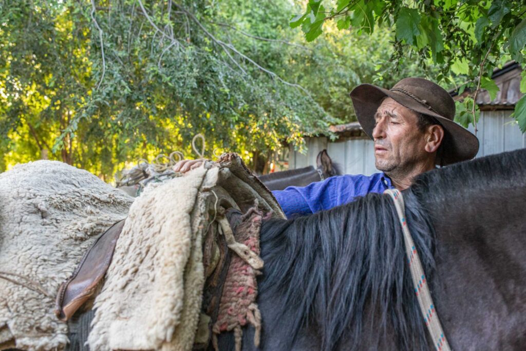 Hombre arreglando la montura del caballo. Foto: Fundación Madrugada 