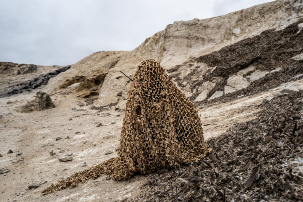 Susana Cárdenas Alayza, Directora del Programa Punta San Juan, se camufla con el entorno para poder observar a los pingüinos de cerca.