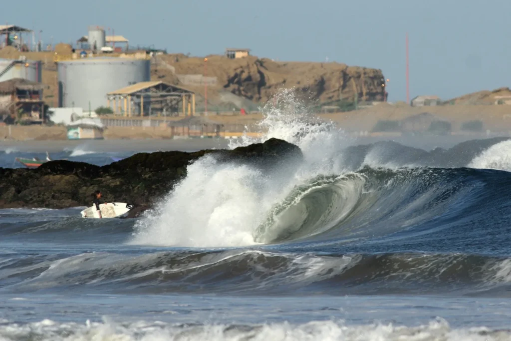 Una persona entrando al mar con una tabla de surf en Lobitos, Perú, donde este deporte genera cerca de cuatro millones de dólares anuales, según Save The Waves (Imagen: Javier Larrea)