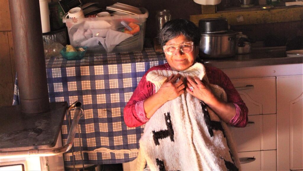 Tejedora mirando con orgullo su trabajo.