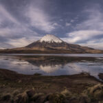 El volcán Parinacota, un imponente estratovolcán de casi 6.350 metros de altura, se alza en la frontera entre Chile y Bolivia, dentro del Parque Nacional Lauca. Su cumbre nevada, sus laderas cubiertas de pajonales altoandinos y su simetría casi perfecta. Créditos Tamara Merino/UNESCO