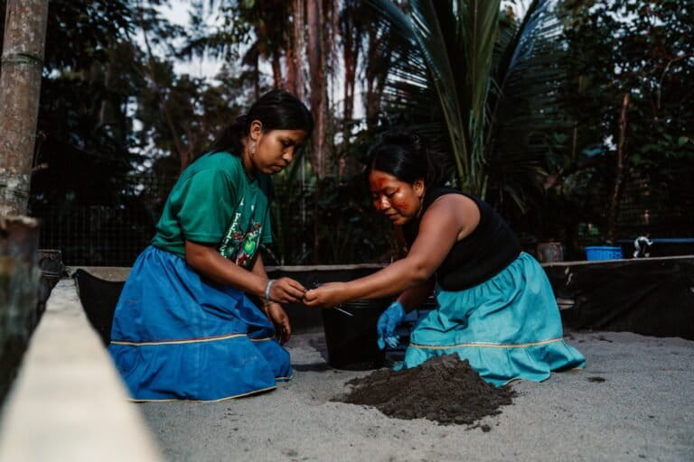 Janeth y Oricel Piaguaje sembrando en el arenario los huevos recolectados en la playa. Créditos: cortesía CI Ecuador