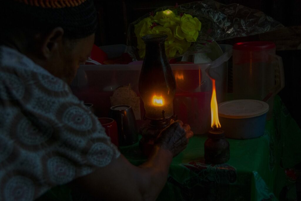 Una habitante de El Cuey, en el Seibo, enseña cómo alumbraba su hogar antes de la llegada de los paneles solares hace unos seis meses. Créditos: Osmil Crooke República Dominicana. 