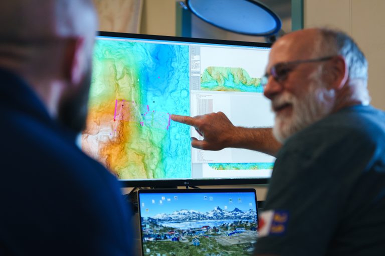 En el Laboratorio de Informática y Electrónica del R/V Falkor (too), el investigador principal David Caress, del Monterey Bay Aquarium Research Institute, repasa los planes de la misión cartográfica con el equipo responsable del vehículo submarino autónomo. El equipo científico utilizó el sonar del buque para cartografiar la región y después empleó el AUV The Childlike Empress para generar mapas de alta resolución y recopilar datos ambientales en el área de interés. Estos mapas permitieron determinar las coordenadas precisas para desplegar el ROV SuBastian, lo que condujo al descubrimiento, en un tiempo récord, de dos nuevos campos hidrotermales activos. Créditos: Alex Ingle, Schmidt Ocean Institute.