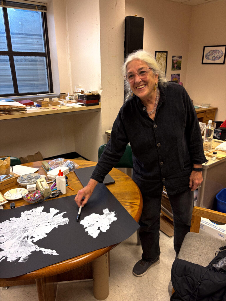 Kathy Ann Miller en su oficina del Herbario de la UC Berkeley. Con el regalo que ADLA le entregó, una serigrafia de una Herborización de Porphyra columbina chilena. Créditos:  Fotografías de la colección del University Herbarium, UC Berkeley