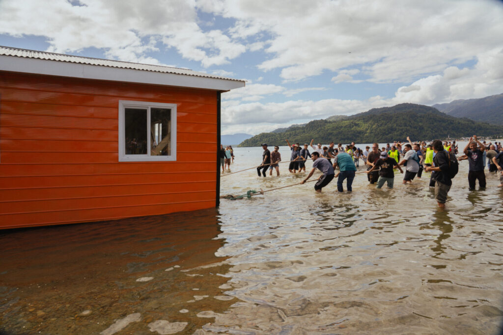 "El Catamarán de Tejuelas", crónica finalista del Premio Nuevas Plumas 2025 sobre la mágica travesía de la casa - minga que se perdió en el mar en clásica celebración de Puerto Cisnes 2025. Créditos (CC-BY): Débora Coronado.