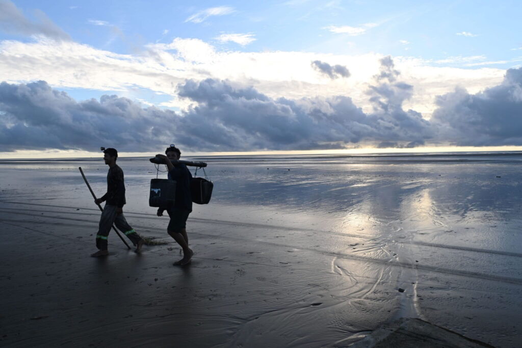 La vida de los pescadores en la desembocadura del Amazonas sigue el ciclo de las mareas. En la playa de Goiabal regresan de recoger los peces atrapados en los estacas con redes. Foto: Luis Ushirobira