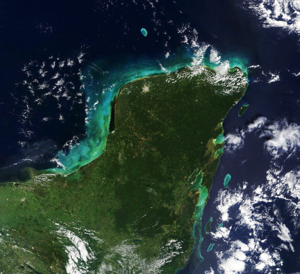 El Anillo de Cenotes, en Yucatán, forma parte de un sistema geológico de origen kárstico que conecta cuevas, cenotes y aguas subterráneas. Este ecosistema alberga especies endémicas y es fundamental para el abastecimiento de agua en la península. Créditos: NASA